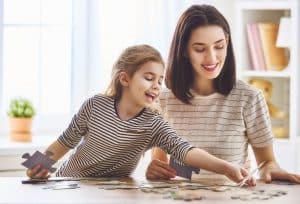 mother and daughter working on a puzzle together